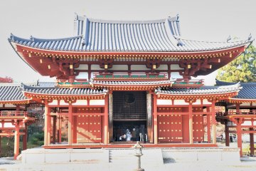 <p>The main chamber of the Phoenix Hall has a cutout window in the shape of a referees' fan, through which the statue of Amida Nyorai can be seen</p>