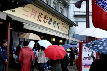 <p>Theater goers under their umbrellas</p>