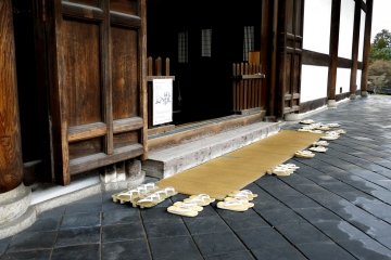 <p>Sandals lined up outside the doors</p>
