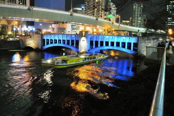 Sebuah bus air meluncur melalui ruang kecil antara air dan Jembatan Nishiki melewati Sungai Tosabori... mendebarkan sekali!