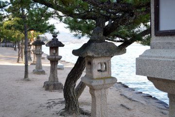 <p>Stone lanterns and tress on the beach</p>