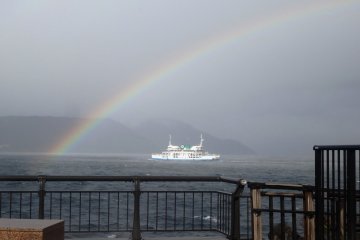 Wet weather produces a rainbow over the ferry that runs to Sakurajima