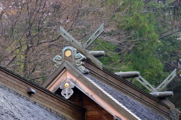 <p>Roof ornaments of the main hall with forest in the background</p>