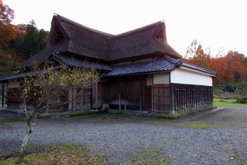 <p>Rumah tua tradisional Jepang beratap jerami di dalam taman</p>