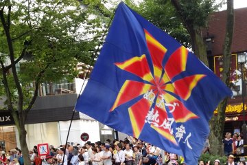 <p>A dancer hoists a huge team banner.</p>