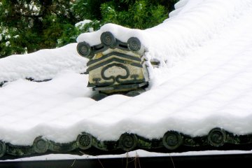 <p>Decorative roof tile poking through the piled snow</p>
