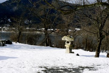Une lanterne de pierre abimée sous la neige