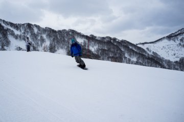 <p>Snowboarder menguji gerakannya di lereng pemula</p>
