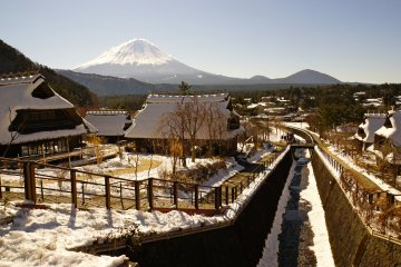 <p>One of the many magical views of Mt. Fuji and the traditional thatched roof houses from Fujimi Bridge</p>