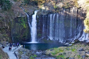 Une magnifique cascade qui se déverse dans un bassin d'un bleu-vert profond