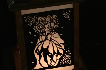 <p>The backlighting&nbsp;shines through the areas where the artist has cut away the black paper.</p>
