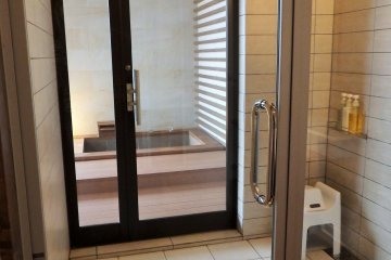 <p>View of the outdoor hot springs bath - looking&nbsp;through the giant shower</p>