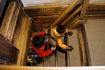 Small children assist one another as they make their way up the challenging staircase