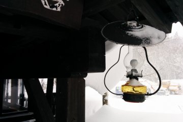 <p>A snowy lantern hangs near the cafe next to the parking lot</p>