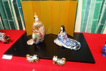 <p>A small pair of dogs accompanies this traditional Hina couple</p>