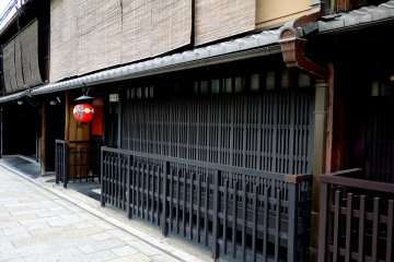 <p>Dark wooden lattice and a red lantern</p>