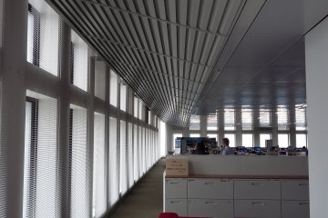 <p>Dari foto bisa dilihat&nbsp;semacam grill&nbsp;di bagian plafon&nbsp;sepanjang jendela. Hal ini berfungsi untuk memasukan cahaya matahari, sehingga di saat siang lampu LED di area ini secara otomatis mati. Ini adalah salah satu bagian dari system saving energy gedung ini.</p>