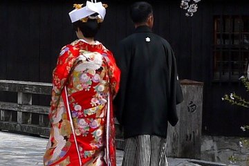 <p>Pasangan muda yang baru menikah berpose untuk difoto di daerah Gion</p>
