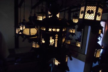 <p>Illuminated lanterns inside the&nbsp;Fujinami-no-ya Hall</p>