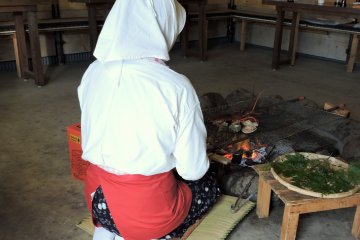 <p>Costumed Ama diver cooking lunch in the Ama hut</p>