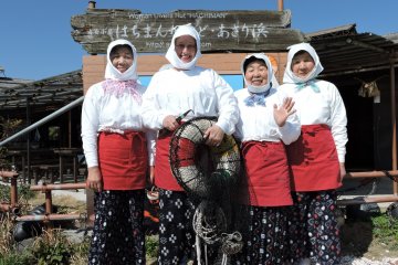 <p>Posing with Ama divers in front of Hachiman-Kamado's signboard</p>