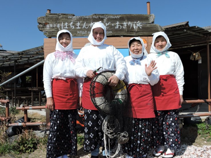 <p>Posing with Ama divers in front of Hachiman-Kamado's signboard</p>
