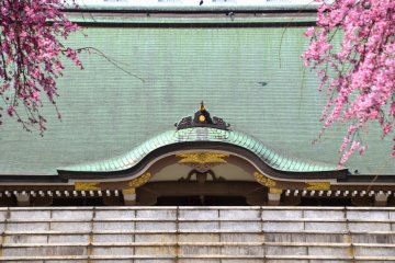 <p>Bangunan utama kuil dihiasi dengan dua pohon sakura yang menjuntai di setipa sisi</p>