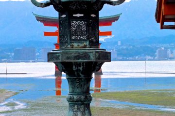 <p>A shrine lantern and torii gate at low tide</p>