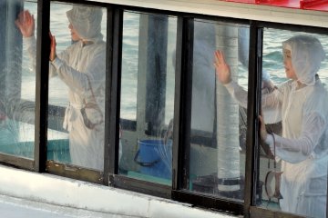 <p>Melambaikan salam perpisahan kepada para turis yang menonton</p>