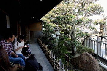 <p>A narrow veranda behind the store overlooks a small Japanese garden</p>