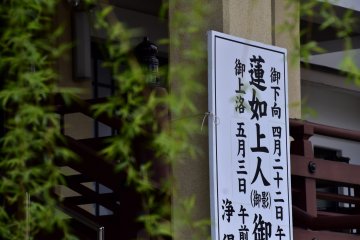 <p>Temple sign viewed through green weeping willow tree leaves</p>