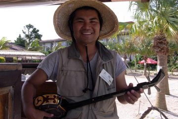 <p>Un homme de la r&eacute;gion prend cinq minutes de son travail pour jouer de la guitare sanshin</p>