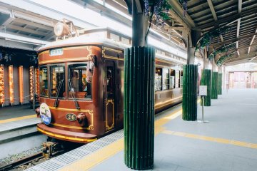<p>Kereta bergaya klasik di&nbsp;Stasiun Randen siap&nbsp;berangkat ke&nbsp;stasiun berikutnya. Terlihat pula beberapa pilar kimono yang terpasang di seluruh&nbsp;penjuru stasiun.</p>