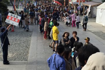 <p>The line to touch the Eko-Bashira. This photo was taken from under the Sanmon Gate facing downhill toward the Niomon Gate.</p>