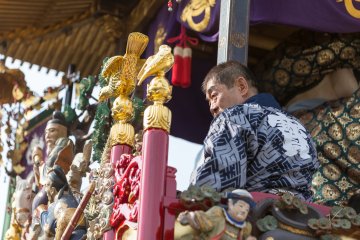 <p>A crew member surveys the crowd from one of the floats</p>