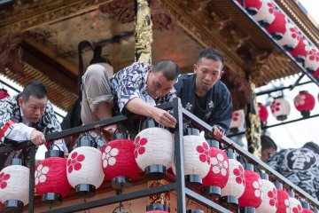 <p>Crew members work to attach lanterns to the floats</p>