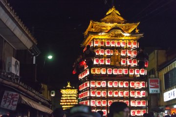 <p>The lantern covered floats make their way through the crowd</p>
