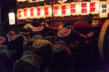<p>Crew members struggle to push the heavy wooden floats uphill</p>