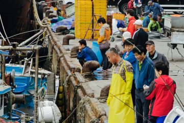 <p>Market traders scanning newly arrived boats</p>