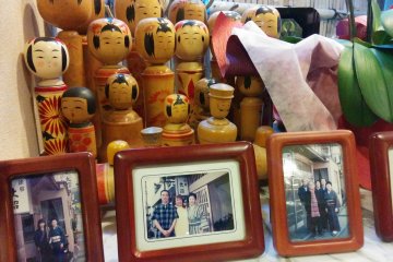 <p>Kokeshi dolls with photos of family and friends of the ryokan&nbsp;add a bit of charm</p>