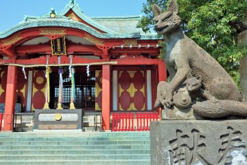 A pair of&nbsp;foxes flank the path leading to the&nbsp;main hall. This one, on the right, holds a fox cub below its paw.