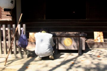 <p>A woman takes five minutes to say a prayer at Konpira-san.</p>