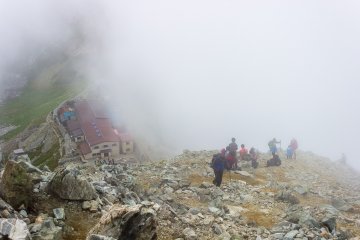 <p>Hikers pause for a rest after the difficult climb up the loose rocks
&nbsp;</p>