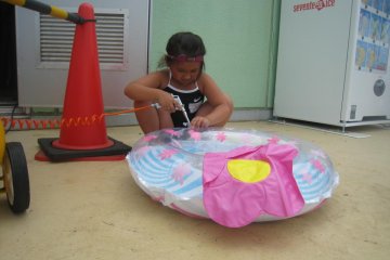 My niece, Miyu, put some air in her floating device with the air-pump-machine as I watched her do it.