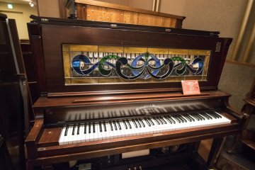 <p>This is no piano. Behind the panel lies the musical box which not only plays the tunes, but also engages the keyboards, making it look like the 'piano' is being performed on.</p>