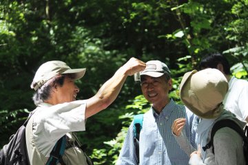 <p>Our guide shows us a tadpole from the nearby pond</p>
