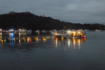 A boat floats lanterns on the lake