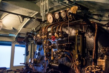 <p>Controlling room of a steam train with many pipes and temperature gauges&nbsp;</p>