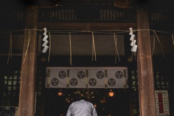 <p>Visitor bowing to the gods after prayer</p>