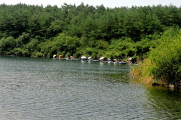 <p>Orang-orang memancing di bawah payung</p>